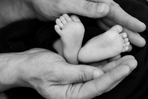 pieds de bébé dans les main de son père